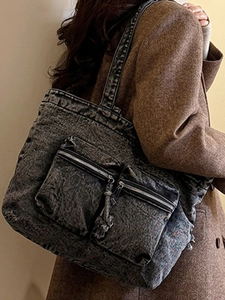 Vintage dark gray washed denim tote bag with dual front zipper pockets on model