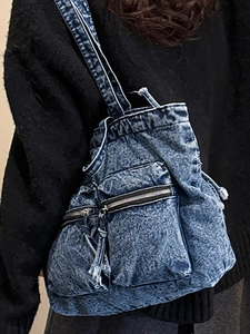 Vintage blue washed denim tote bag with multiple zipper pockets for a casual utility style