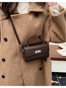 Detail of dark brown vintage small square bag with silver twist lock and slim strap