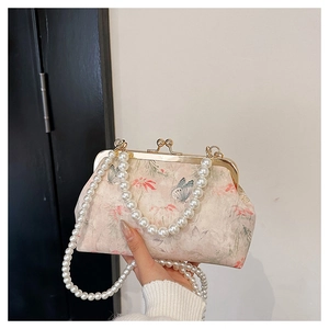 Detail of vintage floral frame clutch with pearl chain straps and gold metal clasp