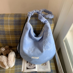 Detail of light blue fuzzy fleece tote bag featuring rabbit embroidery and ruched strap