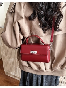 Detail of burgundy leather crossbody bag showing silver hardware and stylish box shape