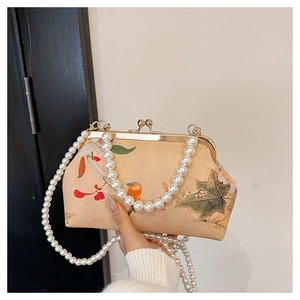 Detailed view of beaded handle and floral embroidery on a vintage style crossbody bag