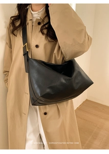 Minimalist black oversized leather tote bag styled with modern retro vibe on a model