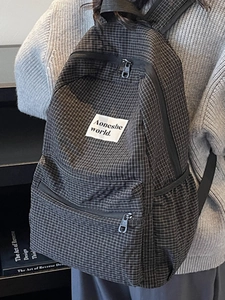 Minimalist black and white plaid canvas backpack with front zipper pocket for school