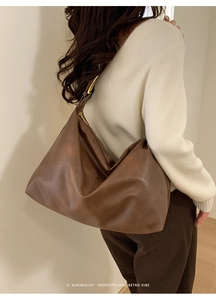 Side view of a brown minimalist leather tote bag with soft texture and retro vibes