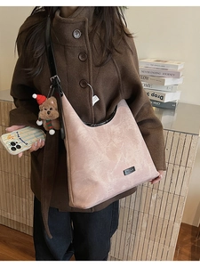 Detailed macro view of pink hobo shoulder bag with marble texture and cute bear charm