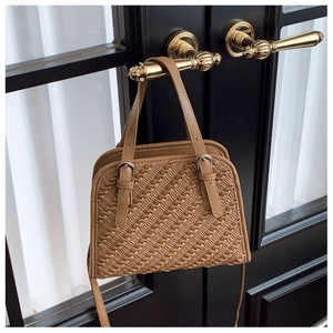 Vue détaillée du tissage marron et des finitions dorées sur un sac à bandoulière chic