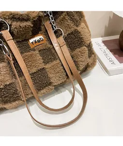 Dettaglio della borsa tote in peluche a scacchi con catena d'argento e trama soffice