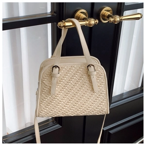 Détail du sac crème plissé montrant la texture douce et la boucle en métal sur la poignée