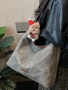 Minimalist grey tote bag with vintage texture and cute bear pendant on a model