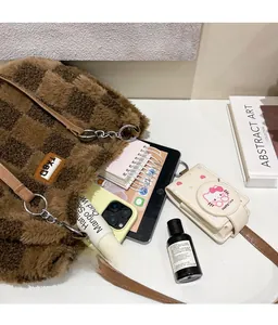 Dettaglio della grande capacità della borsa tote a scacchi in peluche con iPad e oggetti