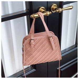 Détail du sac à main rose pâle matelassé à vagues avec accessoires en métal argenté