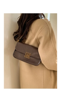 Détails du sac vintage en cuir marron avec boucle dorée et bandoulière chaîne