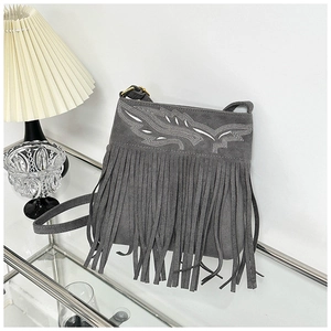Detail view of gray suede shoulder bag with boho fringe and leaf sequin embroidery pattern