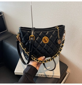 Detail of black quilted bucket bag with gold metal twist lock and dual strap design