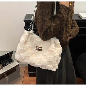 Dettaglio borsa shopper in peluche a scacchi con logo in pelle e tracolla a catena