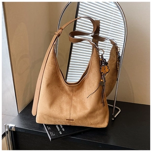 Vue détaillée du grand sac cabas en daim marron avec franges et trèfle doré