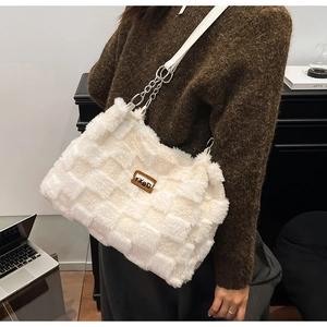 Dettaglio della borsa tote a scacchi in peluche con pelliccia sintetica e catena in pelle