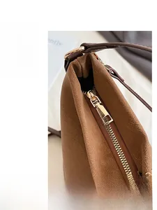 Detailed macro view of caramel leather bag with lychee texture and gold metal zipper