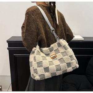 Dettaglio della borsa tote in peluche a scacchi con etichetta in pelle e tracolla a catena