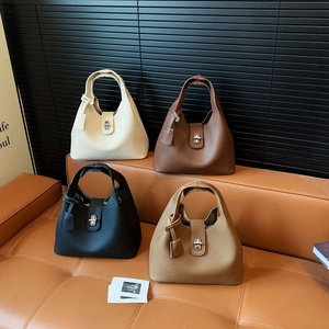 Detail view of four colored bucket bags in lychee grain leather with metal lock closure