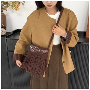Detailed embroidery of white leaves on brown fringe crossbody bag with suede texture