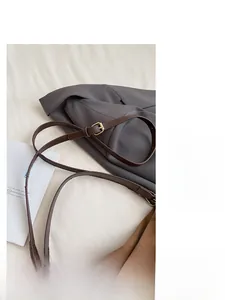 Detail of adjustable brown leather strap with gold buckle on women shoulder bag