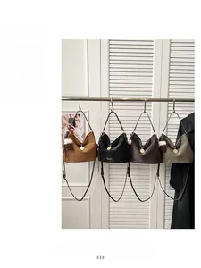 Detail view of retro hobo bags in four colors with metal logo and plush ball charms