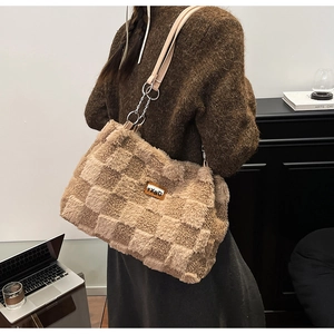 Dettaglio ravvicinato della borsa shopper a scacchi in peluche marrone e beige con logo