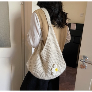 Detailed close-up of beige knit tote bag featuring white 3D daisy floral applique