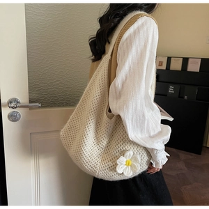Detail of beige crochet knit tote bag with 3D white daisy flower and hollow mesh texture