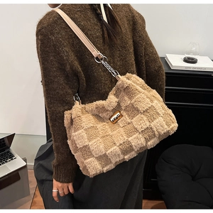 Dettaglio della borsa tote invernale in peluche con motivo a scacchi e tracolla in pelle