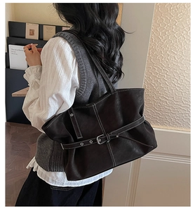 Gros plan sur un cabas en cuir marron vintage avec coutures blanches et boucle décorative