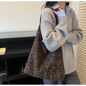 Dettaglio di una grande borsa tote leopardata in maglia marrone portata da una modella