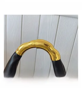 Close-up of the black matte leather handbag with a sleek golden metal handle detail