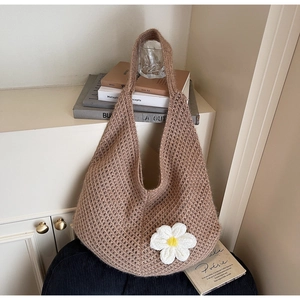 Detail view of khaki knit tote bag featuring a white daisy flower accent and mesh texture