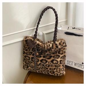Close-up of leopard faux fur tote bag with braided handle and heart-shaped plush charm
