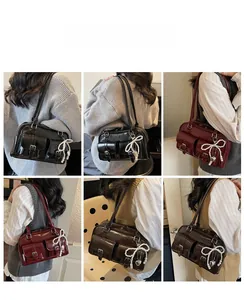 Detail view of retro glossy shoulder bags in black, burgundy, and brown with pocket details
