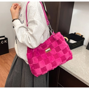 Dettaglio della borsa tote in peluche a scacchi rosa con catena e targhetta in pelle
