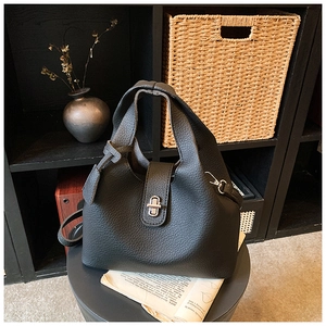 Close-up of black lychee grain leather bucket bag with silver metal swivel lock