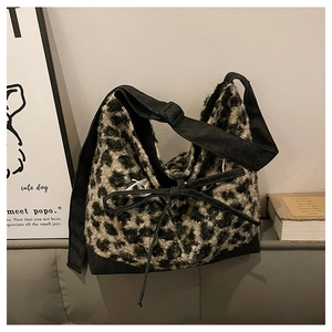 Detail of leopard print plush tote with soft faux fur texture and black bow tie