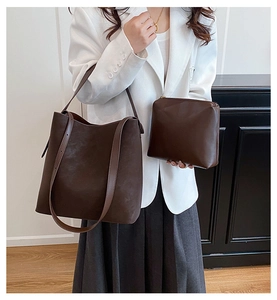 Dettaglio della borsa tote in pelle marrone opaca con pochette abbinata sul modello