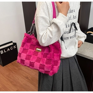 Dettaglio della borsa in peluche fucsia con trama a scacchi e tracolla a catena in metallo