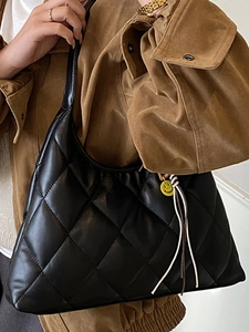 Vintage quilted black hobo shoulder bag with a smiley charm and tassel detail