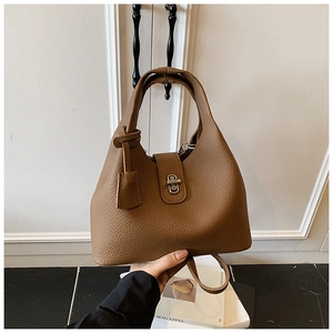 Detail of brown litchi pattern leather bucket bag with silver twist lock and handle