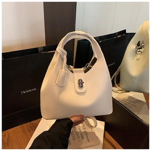 Close-up of cream textured leather bucket bag featuring silver metal twist lock closure