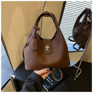 Close-up of brown litchi pattern leather bucket bag with silver twist lock and handle