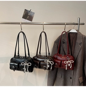 Detailed view of three vintage-style bowling bags in black, dark brown and burgundy leather