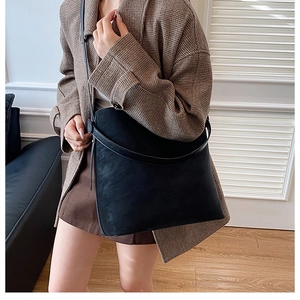 Dettaglio della borsa tote nera opaca sulla modella che mostra la texture e lo stile urbano